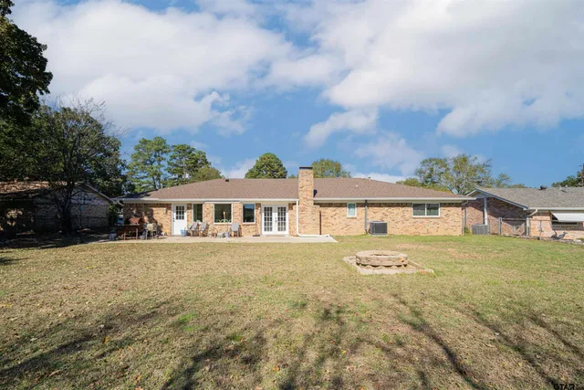 a view of a house with a big yard and large trees