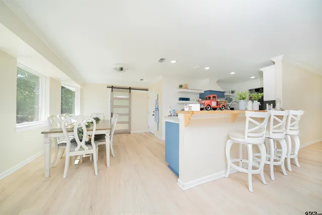 a kitchen with a dining table chairs and white appliances