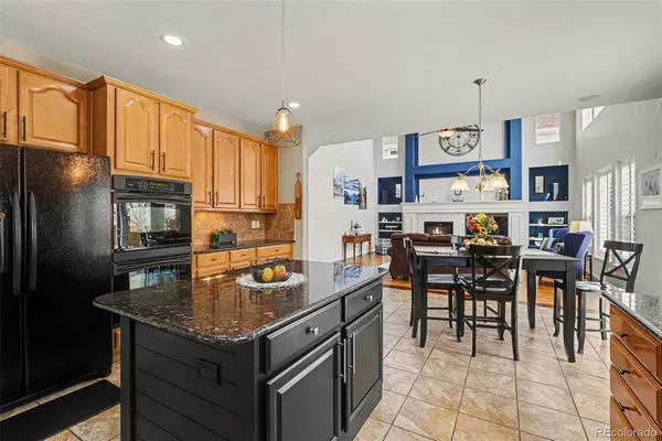 a kitchen with stainless steel appliances granite countertop a stove refrigerator and cabinets