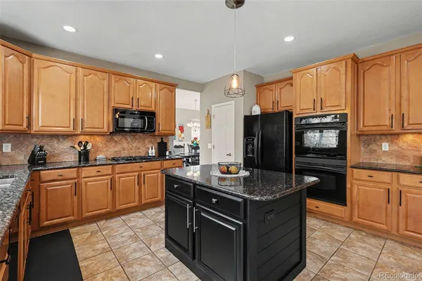 a kitchen with stainless steel appliances granite countertop a stove microwave and refrigerator
