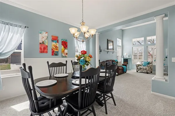 a view of a dining room with furniture a chandelier and a window