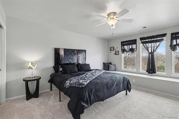 a bedroom with a bed and a large window with a chandelier