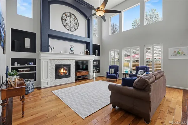 a living room with furniture a clock and a fireplace