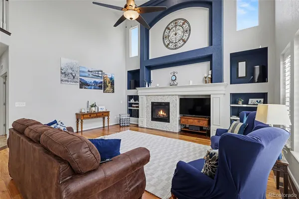 a living room with furniture a flat screen tv and a fireplace