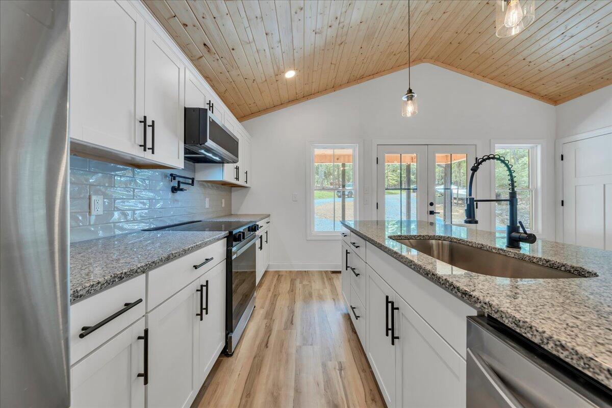 2365 Lakewood Forest Road Moneta, VA 24121 - Photo 19 of 90 a large kitchen with granite countertop a sink and dishwasher with a large window