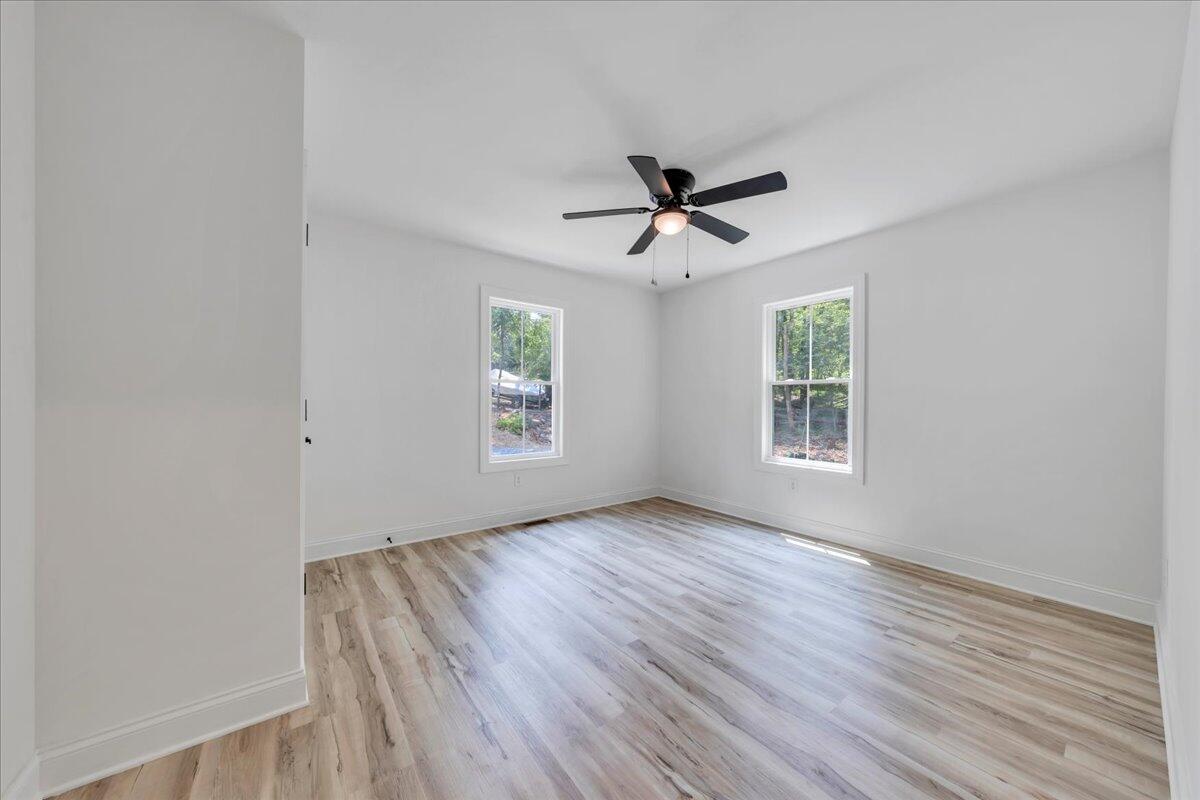 2365 Lakewood Forest Road Moneta, VA 24121 - Photo 27 of 90 an empty room with wooden floor ceiling fan and windows