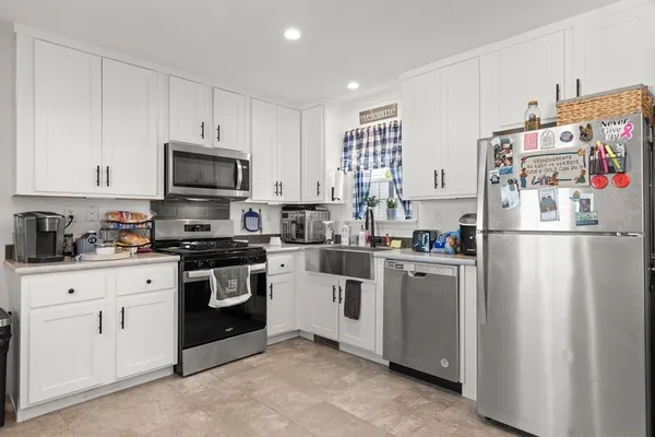 a kitchen with refrigerator a microwave a stove and cabinets