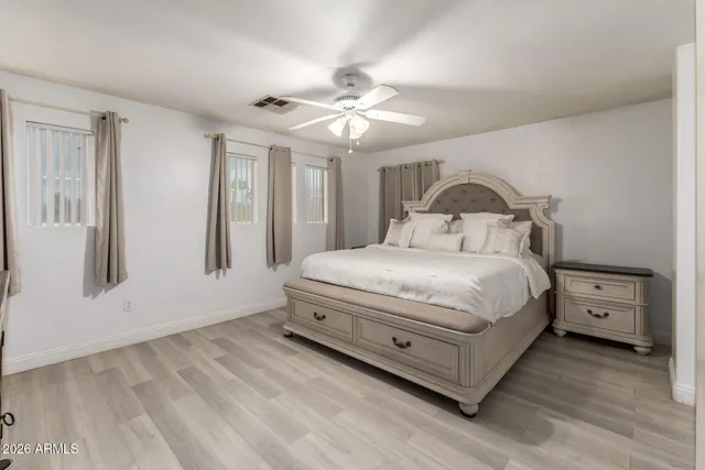 a bedroom with a large bed and a chandelier