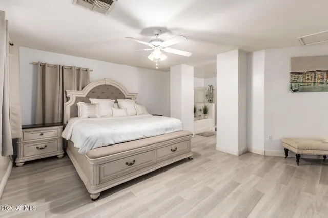 a bedroom with a large bed and a chandelier