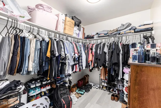 a view of walk in closet with clothes and shoes