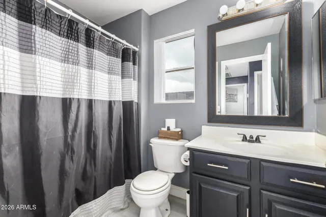 a bedroom with a bed lamp and wall painting