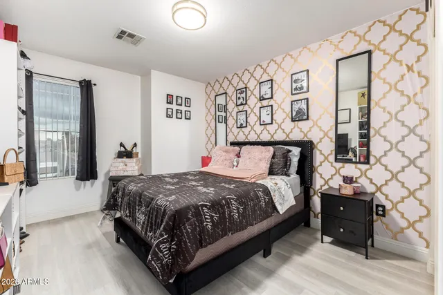 a bedroom with a bed a flat screen tv and a window