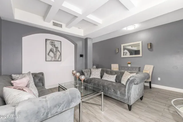 a living room with furniture and a painting on the wall