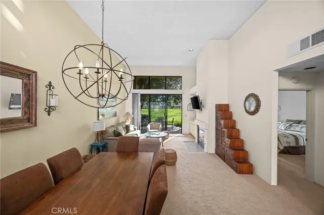 a living room with furniture a fireplace and a chandelier