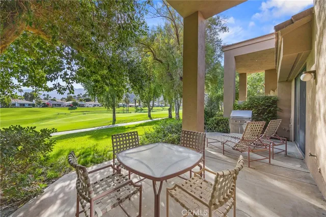 a view of a patio with a table chairs and a backyard