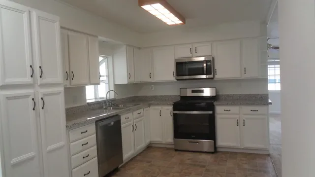 a kitchen with white cabinets and stainless steel appliances