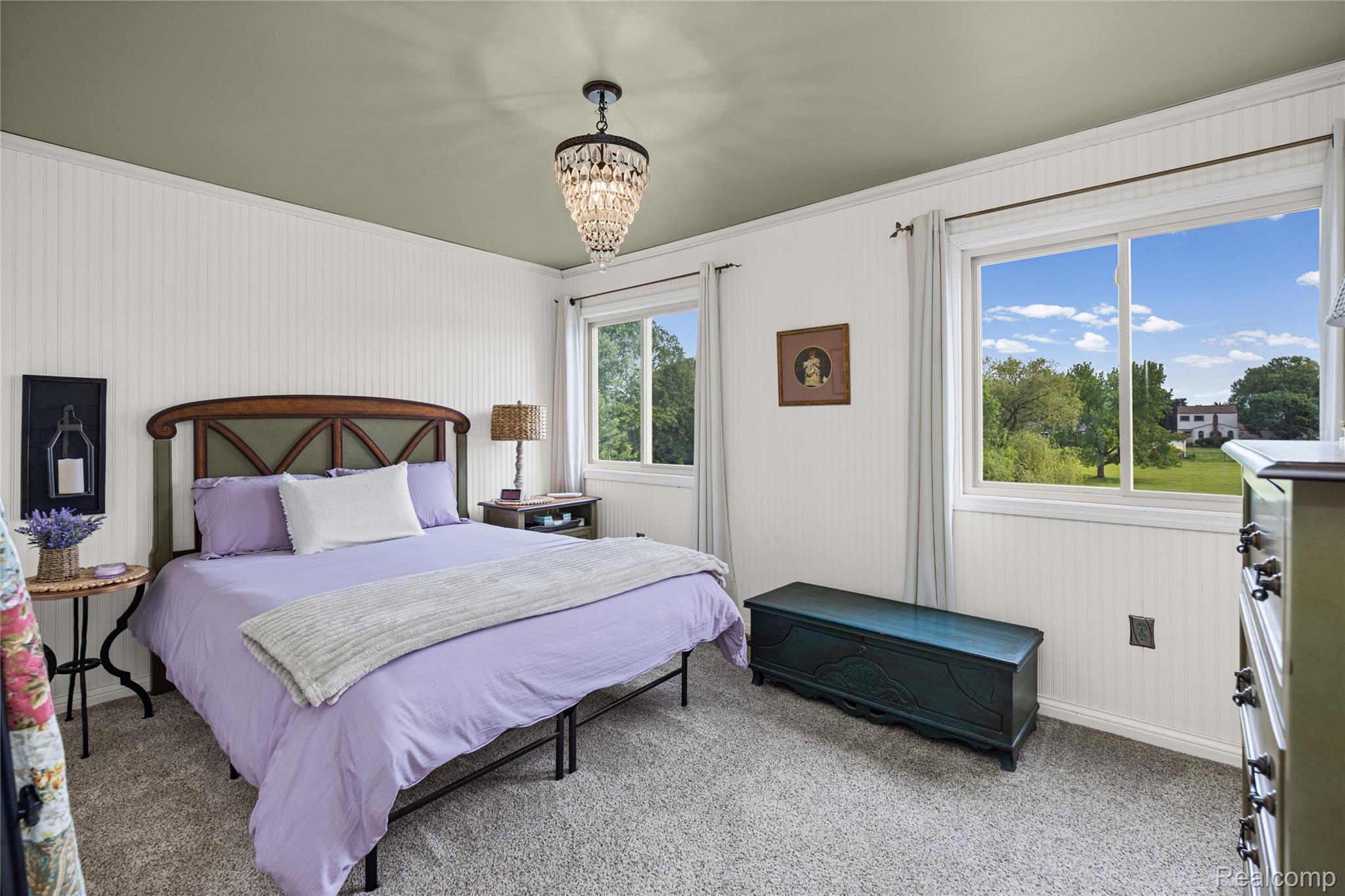 3553 Loon Lake Road Wixom, MI 48393 - Photo 11 of 25 Carpeted room featuring beadboard wall paneling, a decorative chandelier, and two windows providing abundant natural light