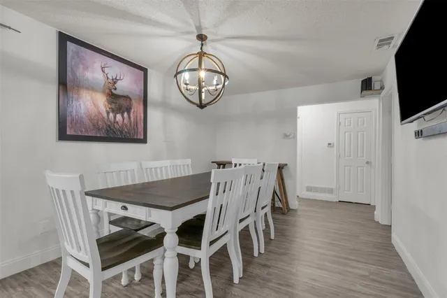 a view of a dining room with furniture wooden floor and chandelier