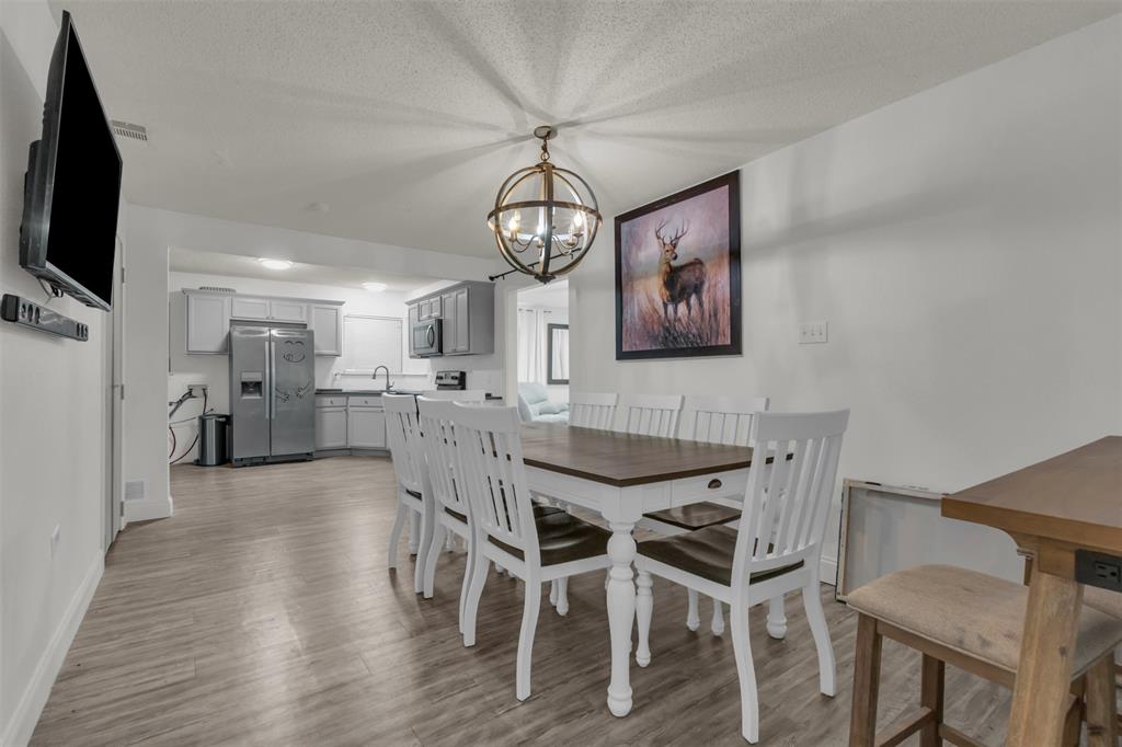 929 North Hall Street Lancaster, TX 75146 - Photo 14 of 24 a view of a dining room with furniture wooden floor and a chandelier