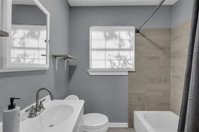 a bathroom with a sink toilet a mirror and shower