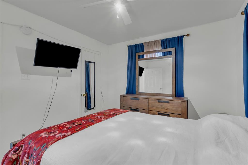 929 North Hall Street Lancaster, TX 75146 - Photo 17 of 24 a bedroom with a bed and a flat screen tv