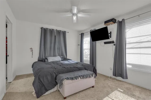 a spacious bedroom with a bed and a flat screen tv