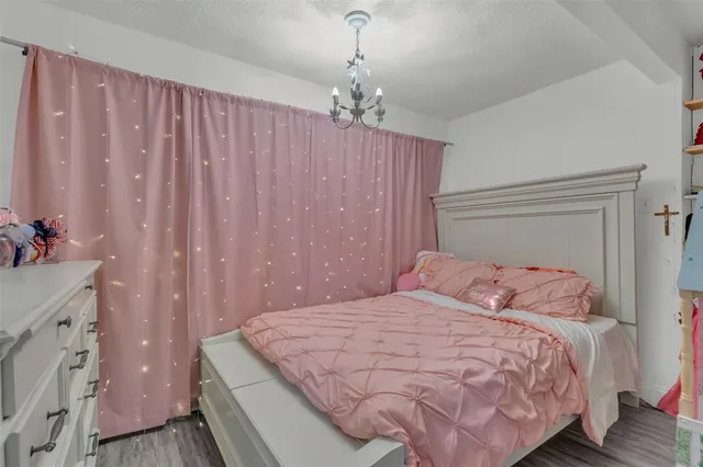 a bedroom with a large bed and a chandelier