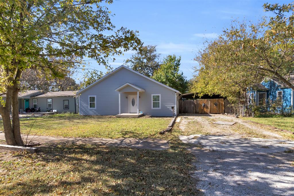 929 North Hall Street Lancaster, TX 75146 - Photo 4 of 24 a house that has a big yard with wooden fence and large trees