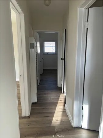 a view of a hallway with wooden floor and closet