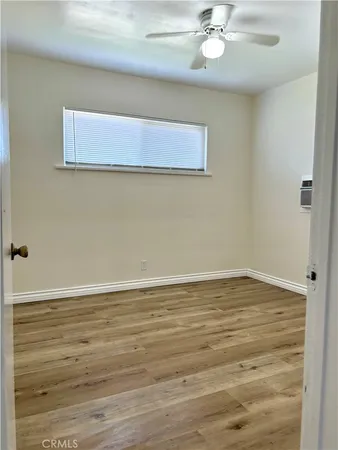 a view of a room with wooden floor and a ceiling fan