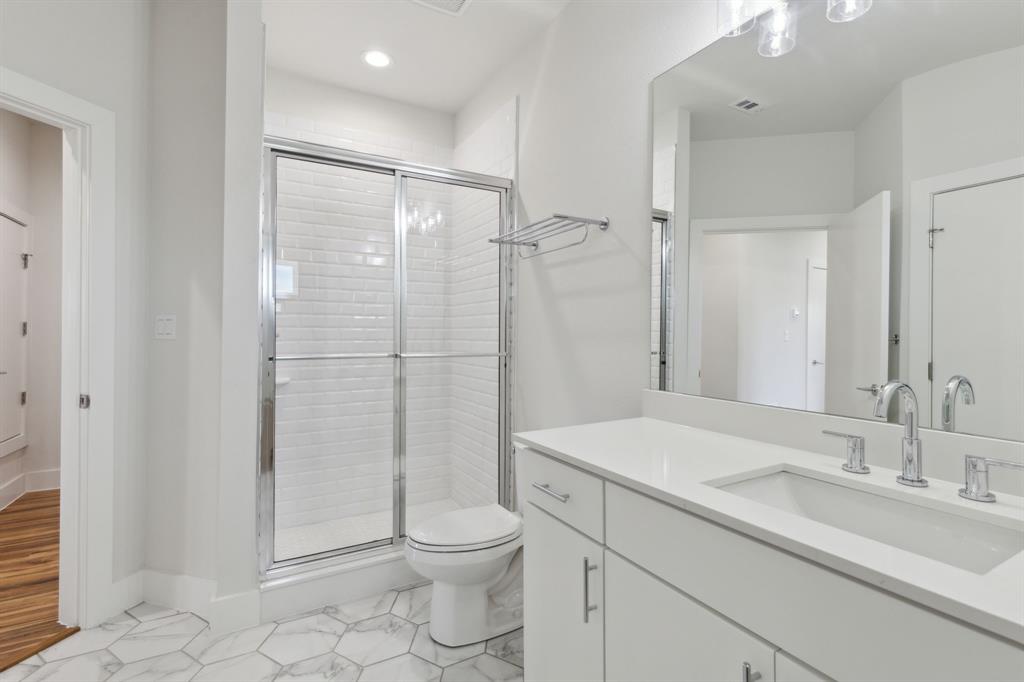 2990 Reagan Street Dallas, TX 75219 - Photo 9 of 20 a bathroom with a shower sink vanity mirror and toilet
