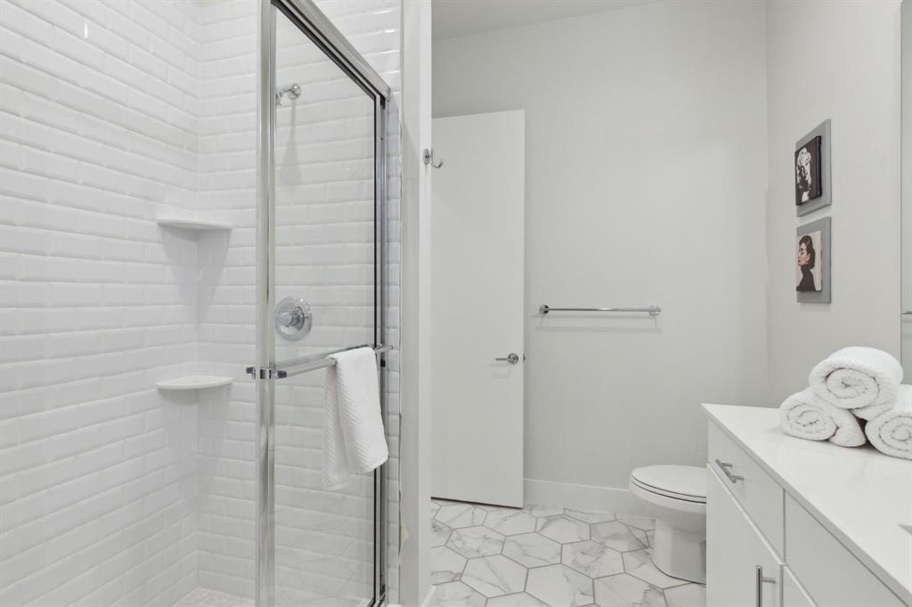 2990 Reagan Street Dallas, TX 75219 - Photo 10 of 20 a bathroom with a toilet a sink and shower