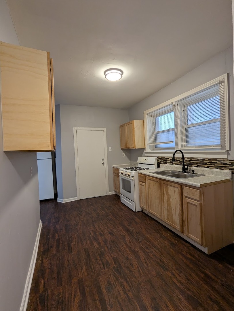 7545 South May Street Chicago, IL 60620 - Photo 11 of 18 a kitchen with granite countertop a stove and a sink