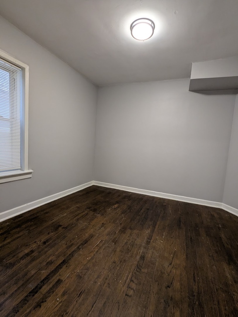 7545 South May Street Chicago, IL 60620 - Photo 13 of 18 an empty room with wooden floor and windows