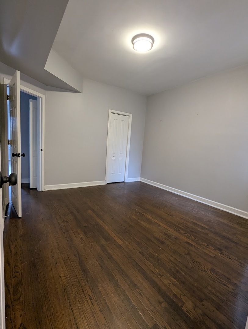 7545 South May Street Chicago, IL 60620 - Photo 14 of 18 an empty room with wooden floor and windows