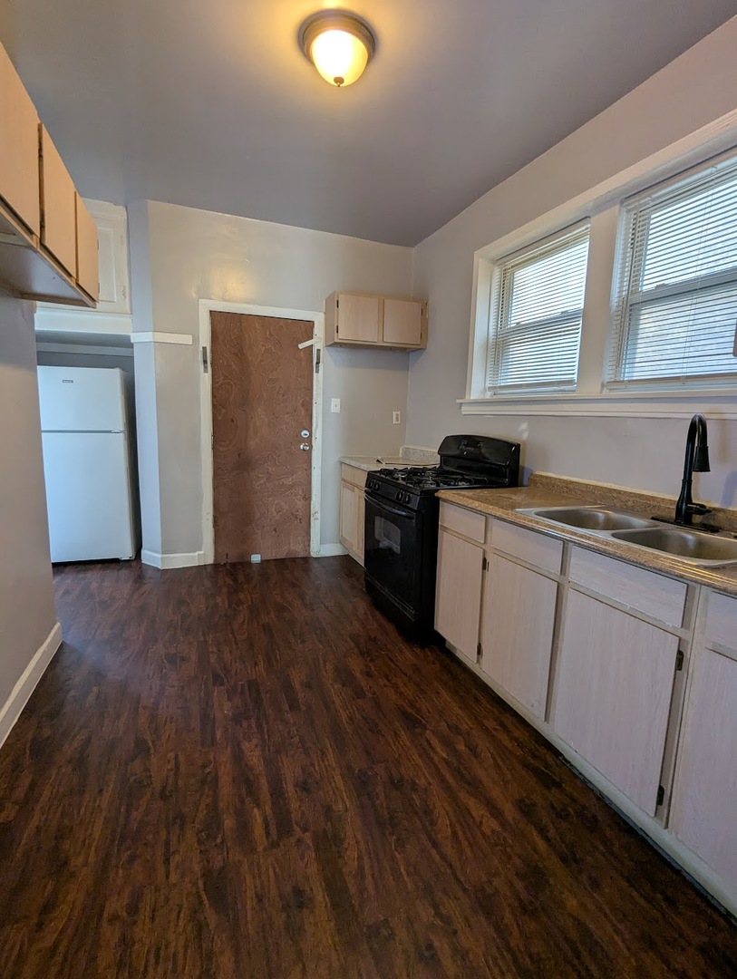 7545 South May Street Chicago, IL 60620 - Photo 17 of 18 a kitchen with granite countertop a sink and cabinets