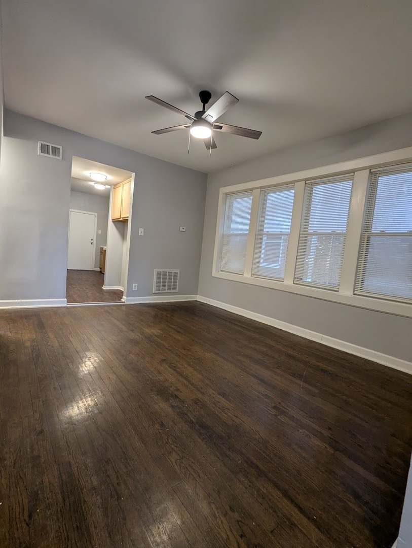 7545 South May Street Chicago, IL 60620 - Photo 3 of 18 a view of an empty room with window and wooden floor