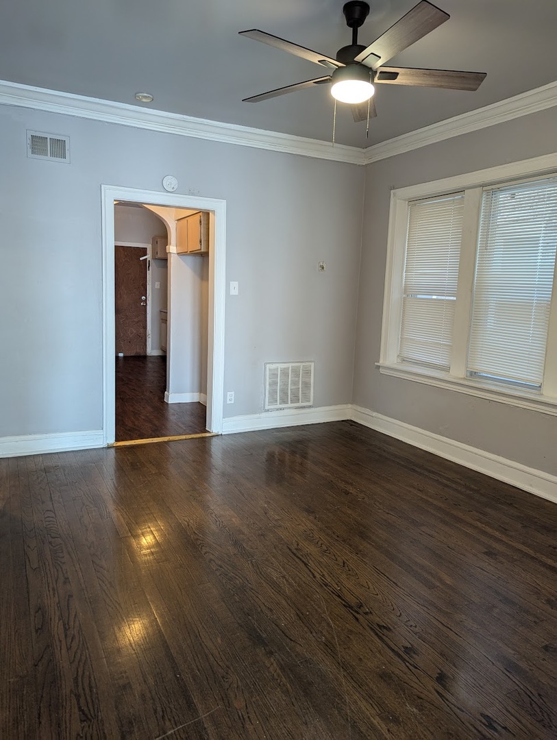 7545 South May Street Chicago, IL 60620 - Photo 4 of 18 a view of an empty room with wooden floor and a window