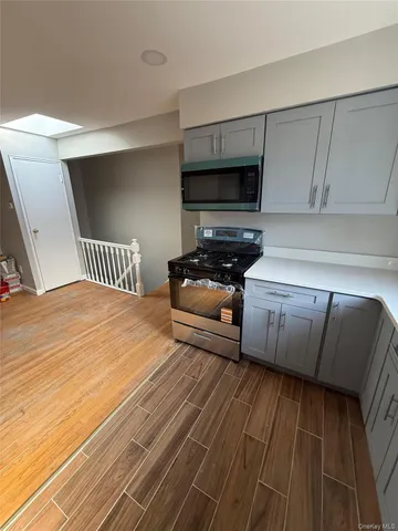 a bedroom with a bed wooden floor and flat screen tv
