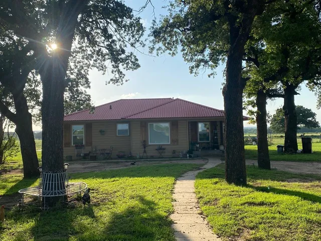 a backyard of a house with yard tree and outdoor seating