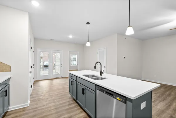 a kitchen with a sink chandelier and wooden floor