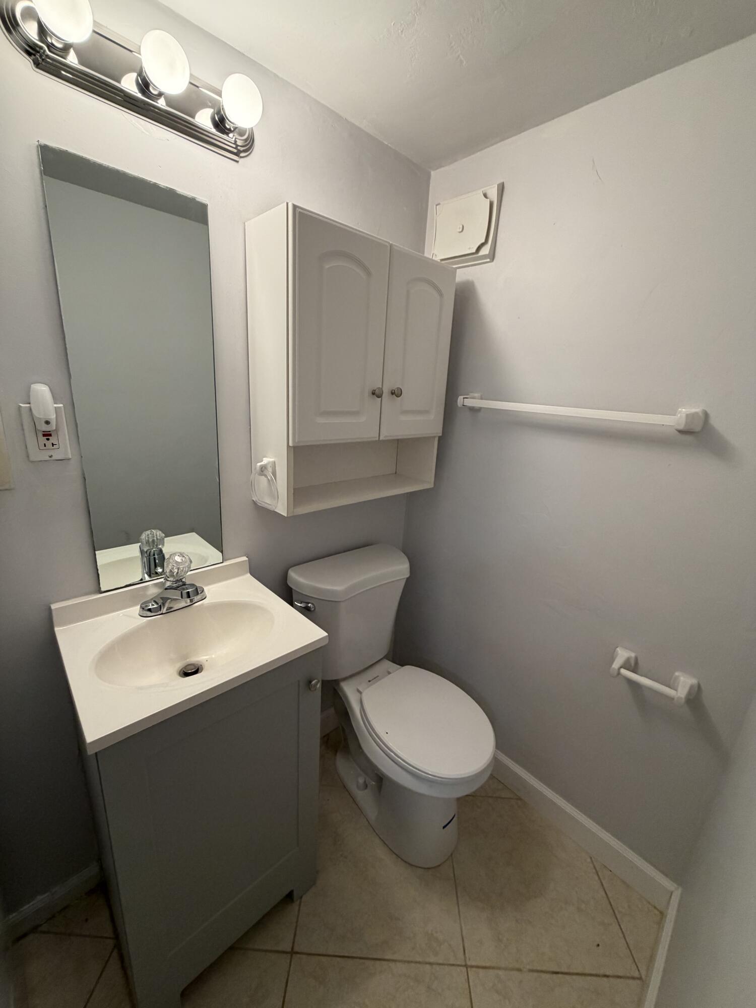 3225 Northeast 21st Avenue, Unit 7 Lighthouse Point, FL 33064 - Photo 19 of 28 a bathroom with a toilet sink and mirror
