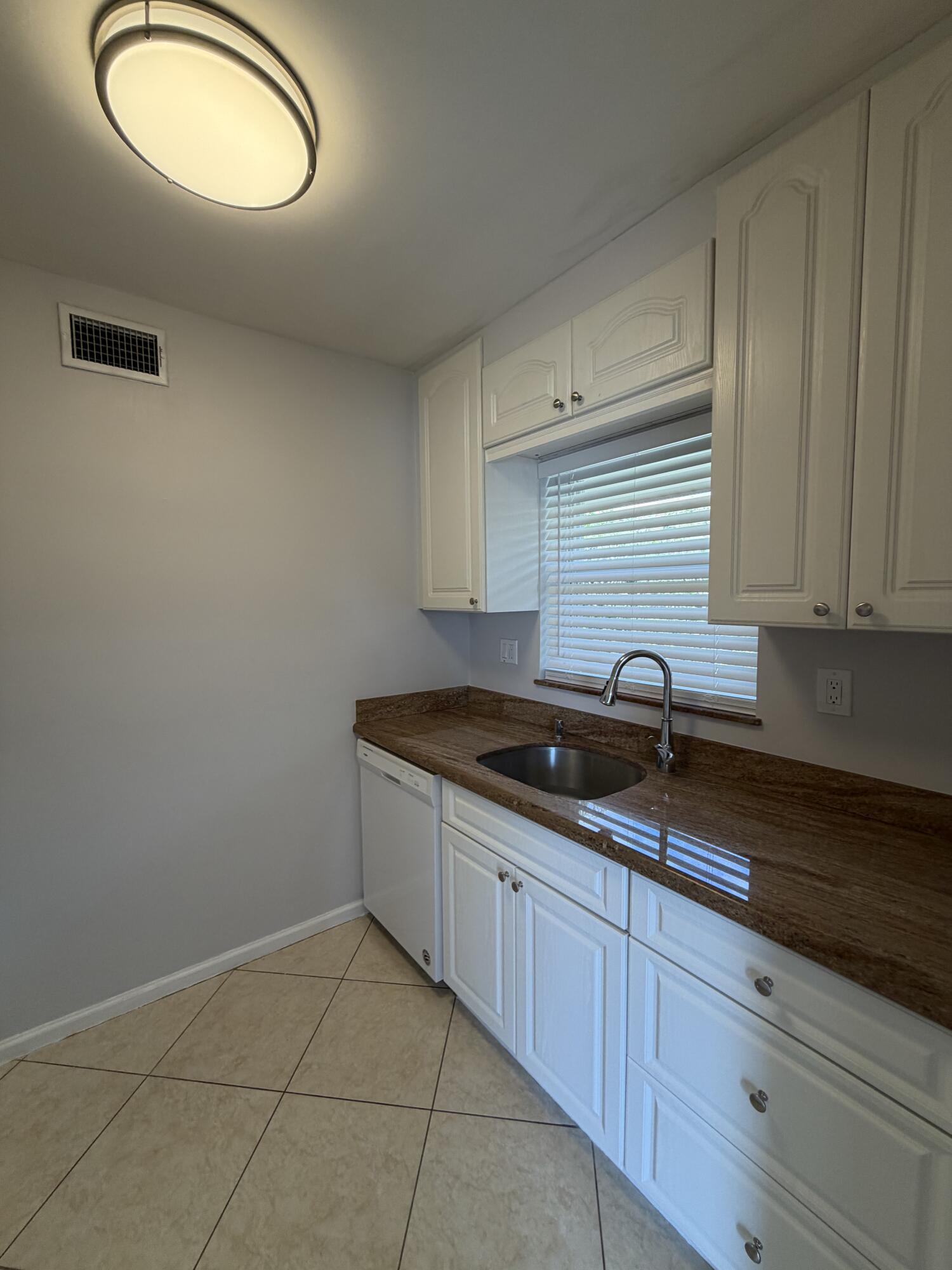 3225 Northeast 21st Avenue, Unit 7 Lighthouse Point, FL 33064 - Photo 7 of 28 a kitchen with a sink and cabinets