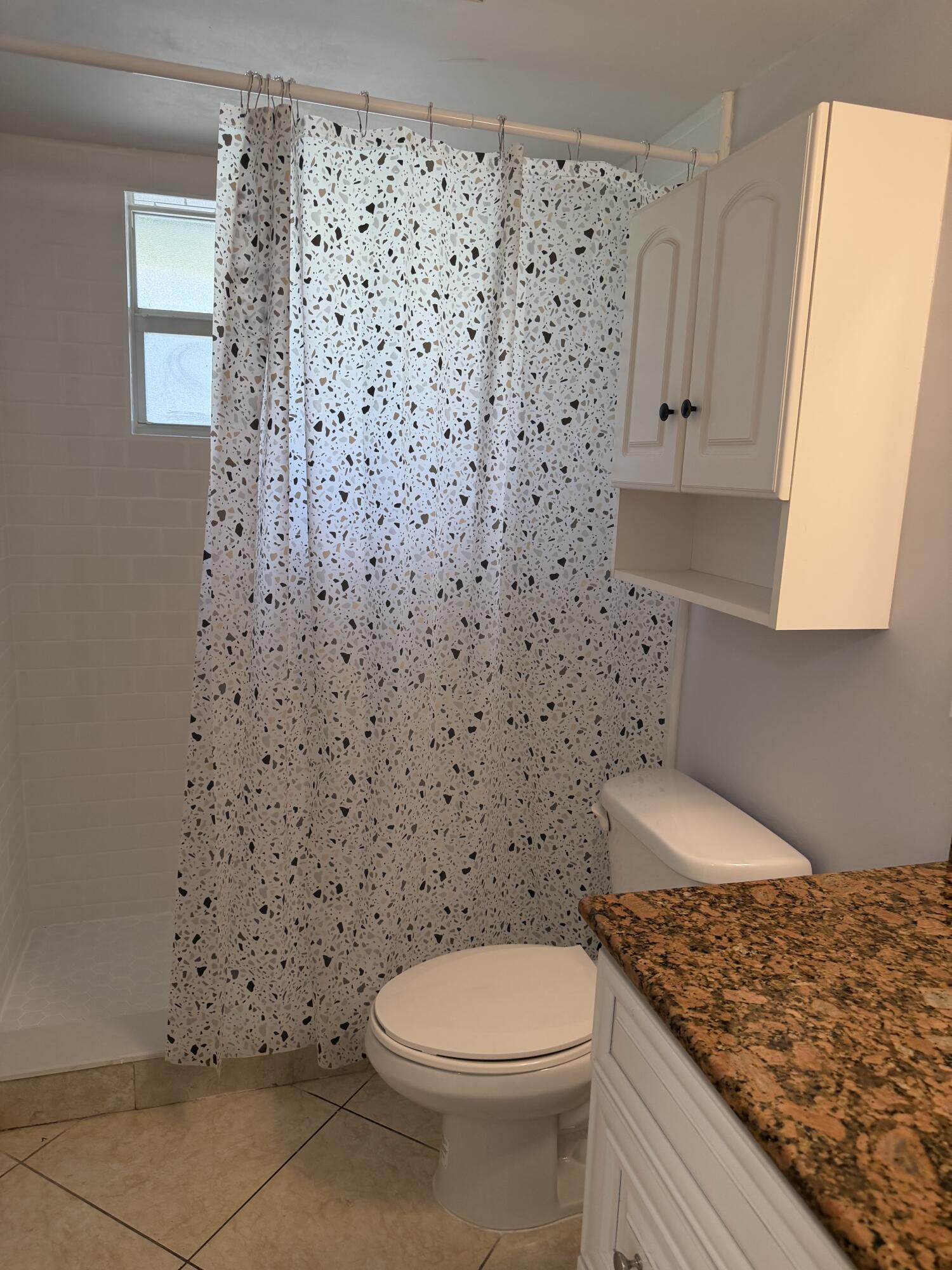 3225 Northeast 21st Avenue, Unit 7 Lighthouse Point, FL 33064 - Photo 10 of 28 a bathroom with a granite countertop toilet and a sink