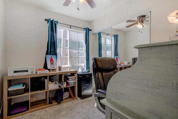 a view of a workspace with furniture and a window