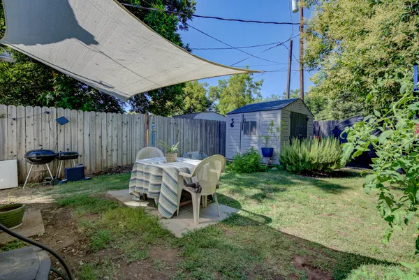 a view of backyard with table and chairs and a large tree