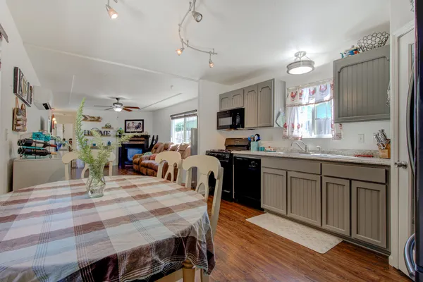 a kitchen with stainless steel appliances granite countertop a stove refrigerator dining table and chairs
