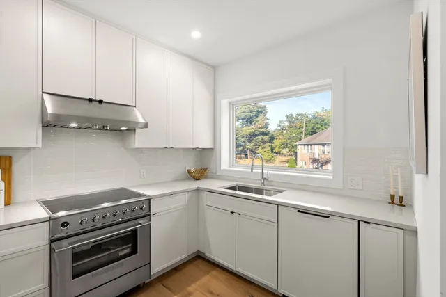 a kitchen with stainless steel appliances white cabinets and a sink