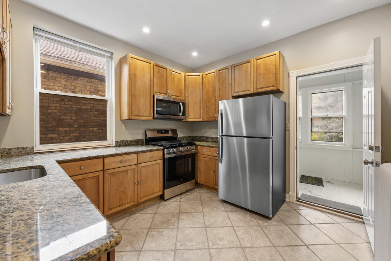 5728 North Maplewood Avenue Chicago, IL 60659 - Photo 11 of 30 a kitchen with stainless steel appliances granite countertop a refrigerator sink and stove
