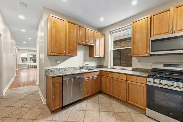 a kitchen with stainless steel appliances granite countertop a stove a sink and a microwave
